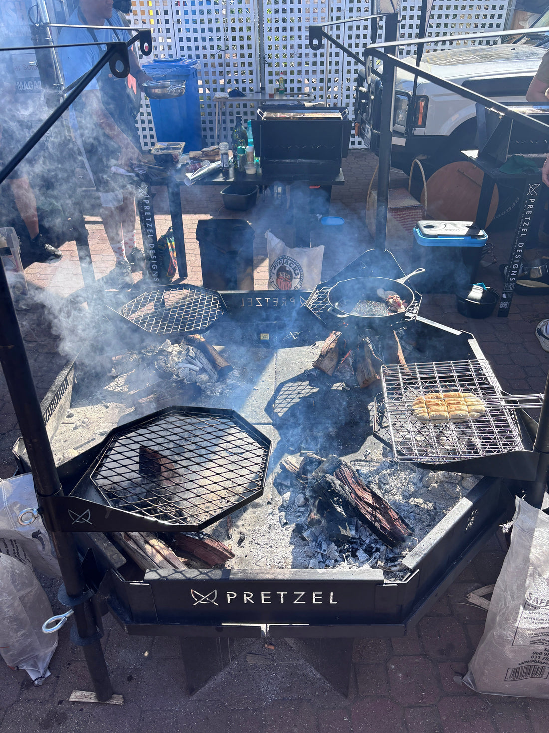 Custom octagonal steel fire pit with four cooking stations and swing-out grids, built by Pretzel Designs for the KhakiBush BraaiBoss Challenge