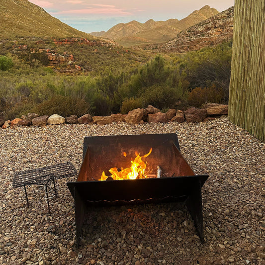 Fire Pit XL burning at dusk on a gravel boma in the mountains