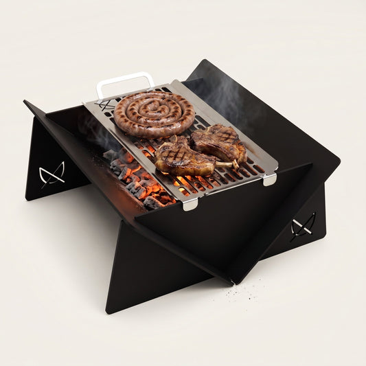 Fire Pit & Grill by Pretzel Designs: black steel fire pit with a stainless steel grill of boerewors and chops over glowing coals